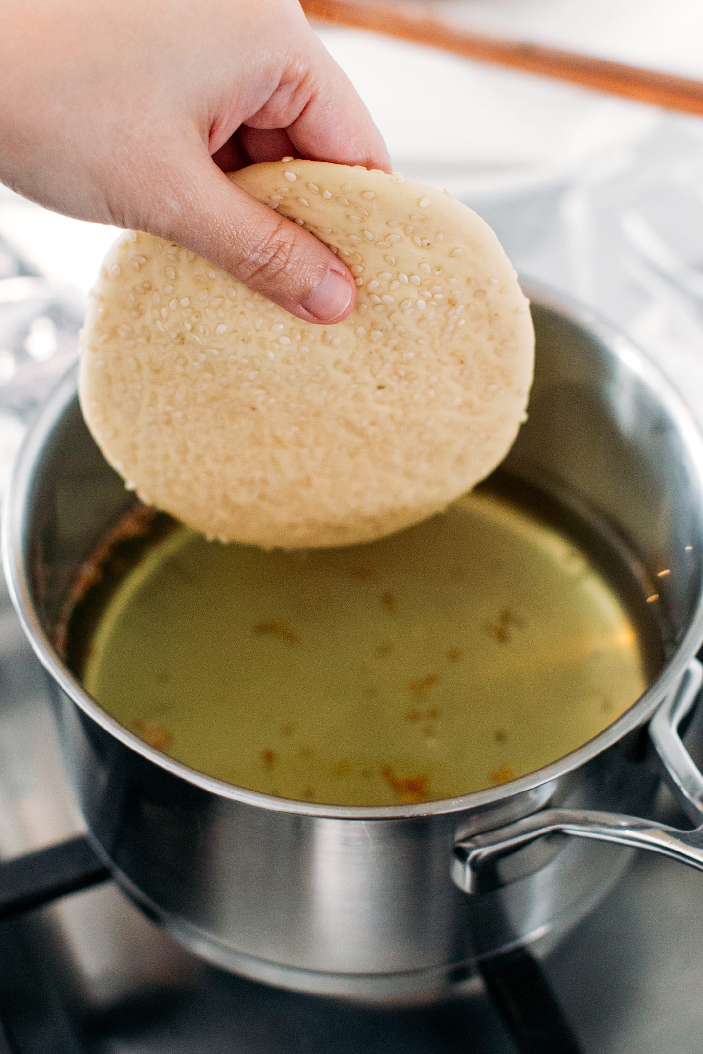 Placing a disc of dough into hot oil.