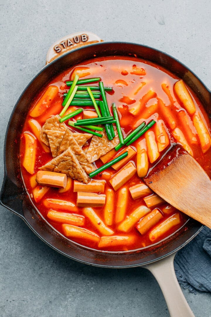 Rice cakes, sausages, and green onions in a gochujang sauce.