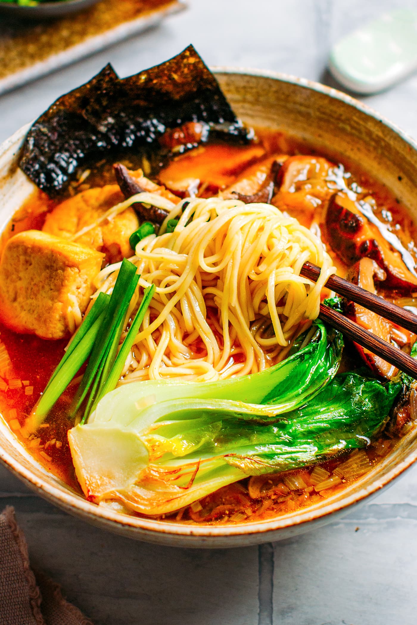 Close-up of vegan ramen with noodles, tofu, mushrooms, and pak choi