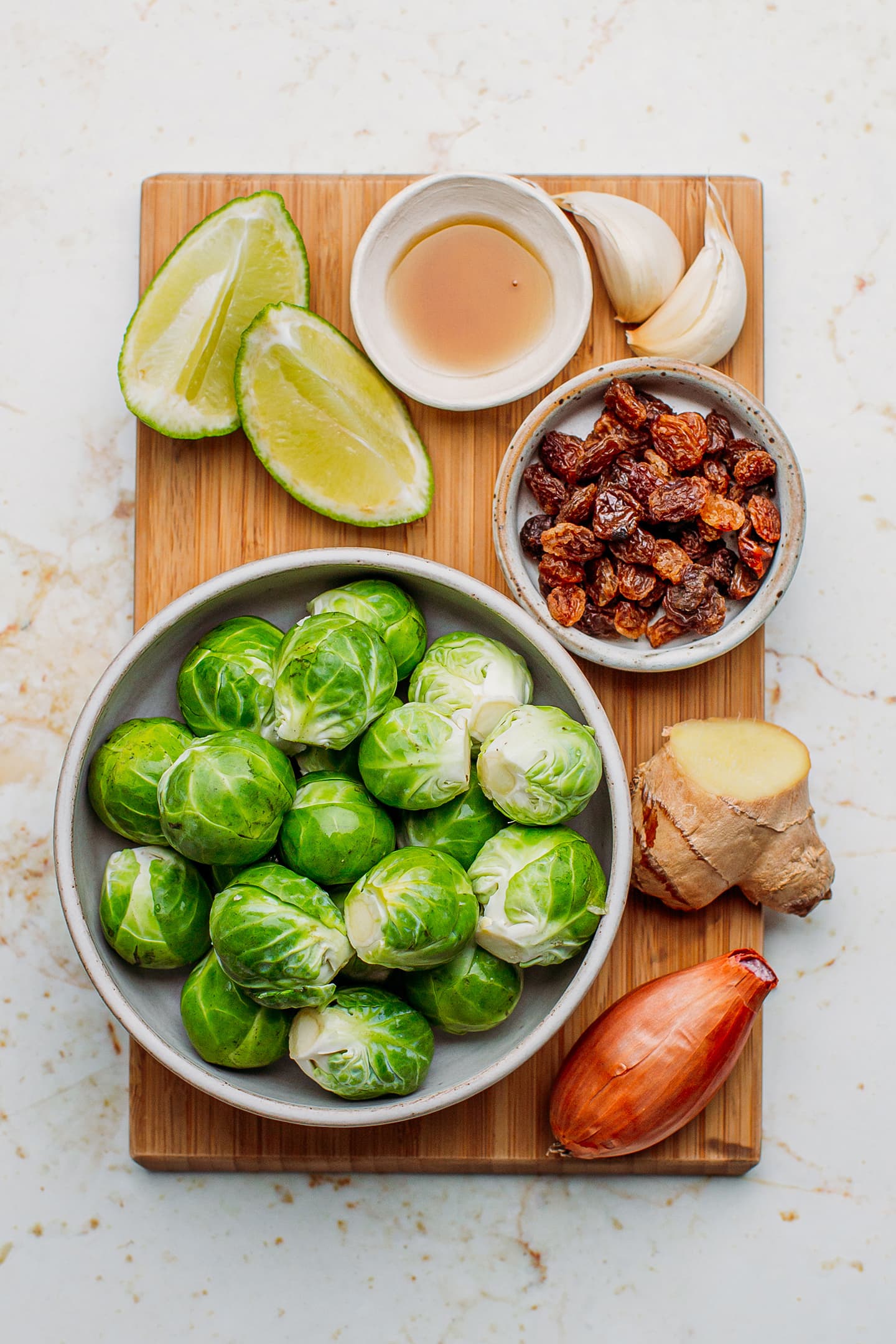 Ingredients like Brussels sprouts, ginger, shallots, raisins, and garlic.
