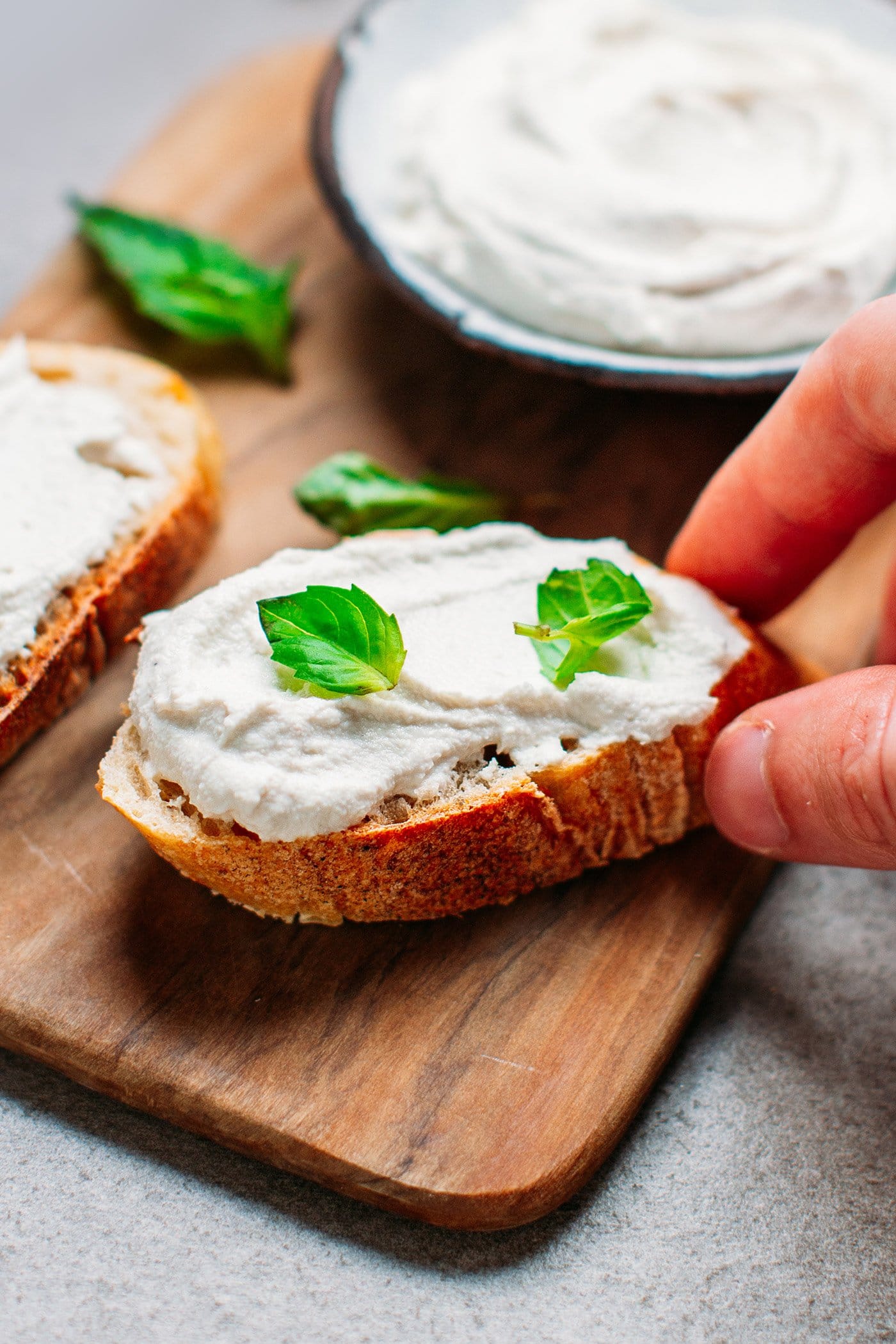 Close-up of vegan cream cheese on a toast with basil leaves