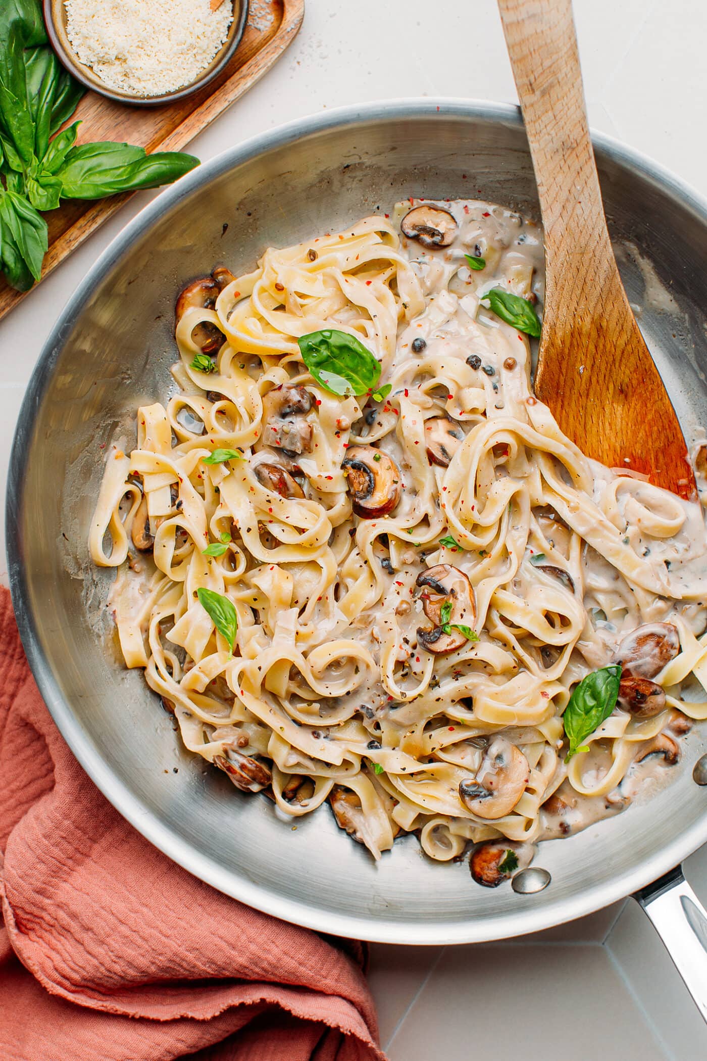 Mushroom pasta tossed with peppercorn sauce in a skillet.