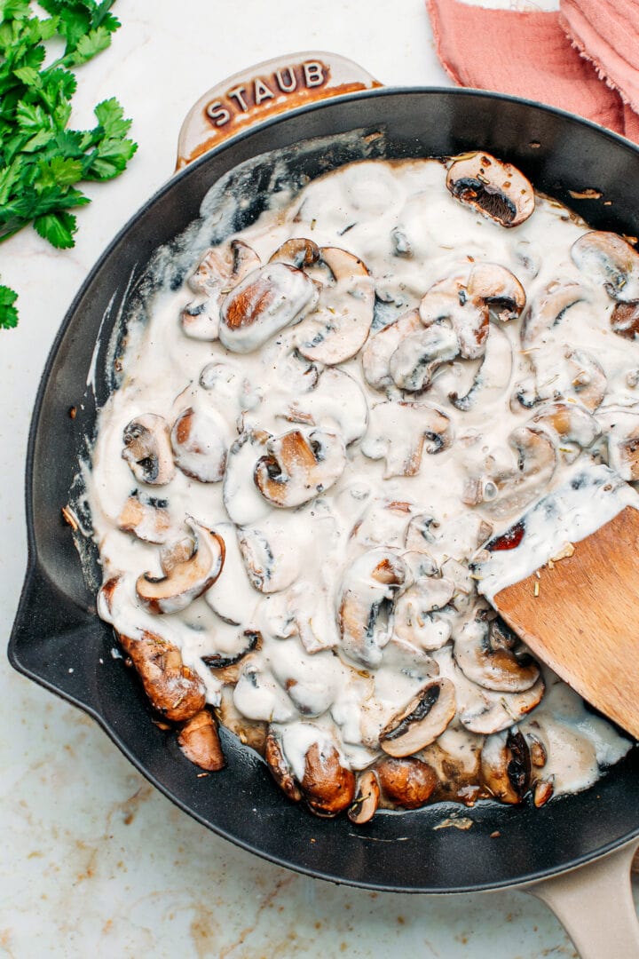 Sautéed mushrooms with cream in a skillet.