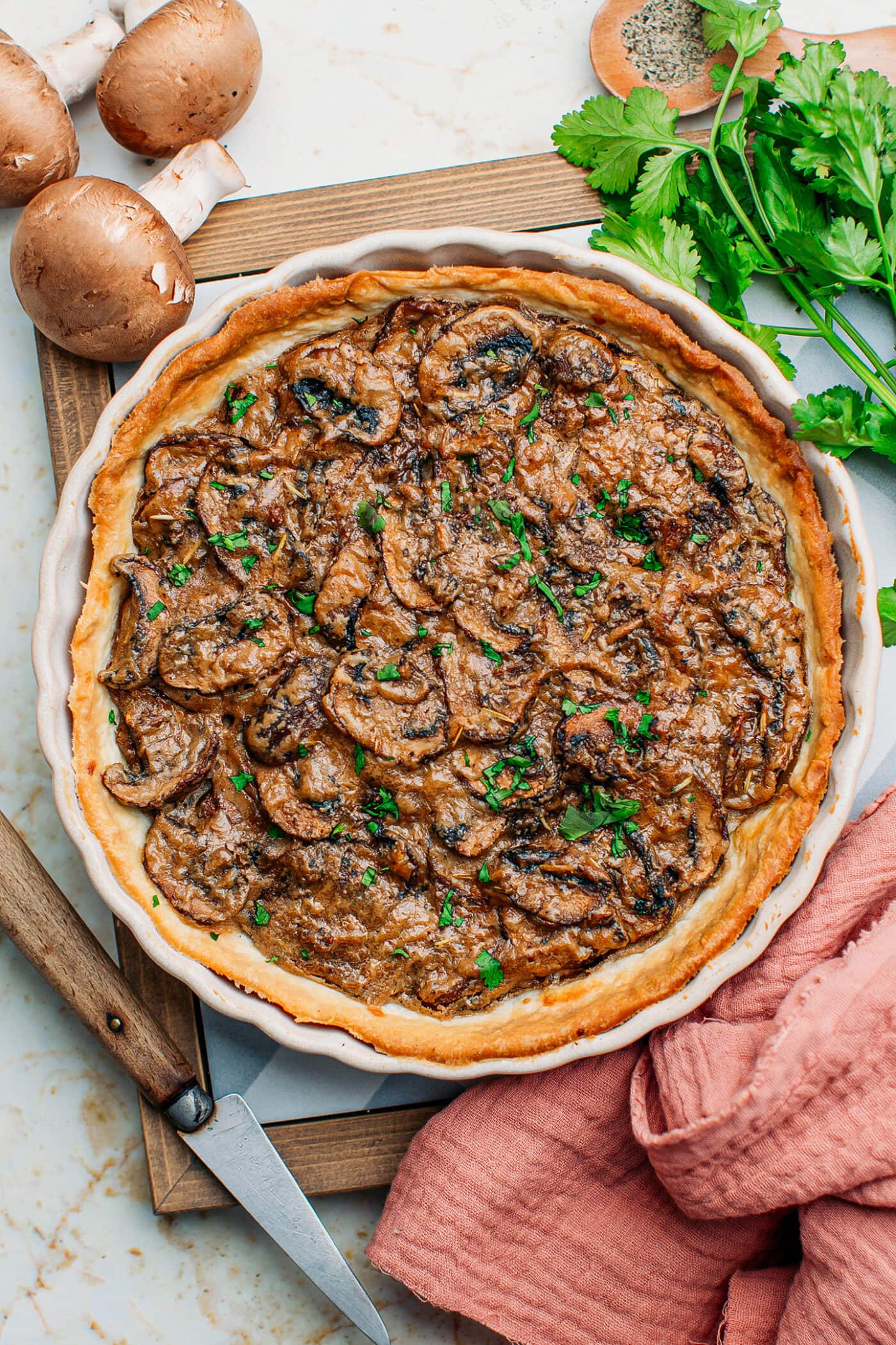 Mushroom tart in a pan topped with chopped cilantro.