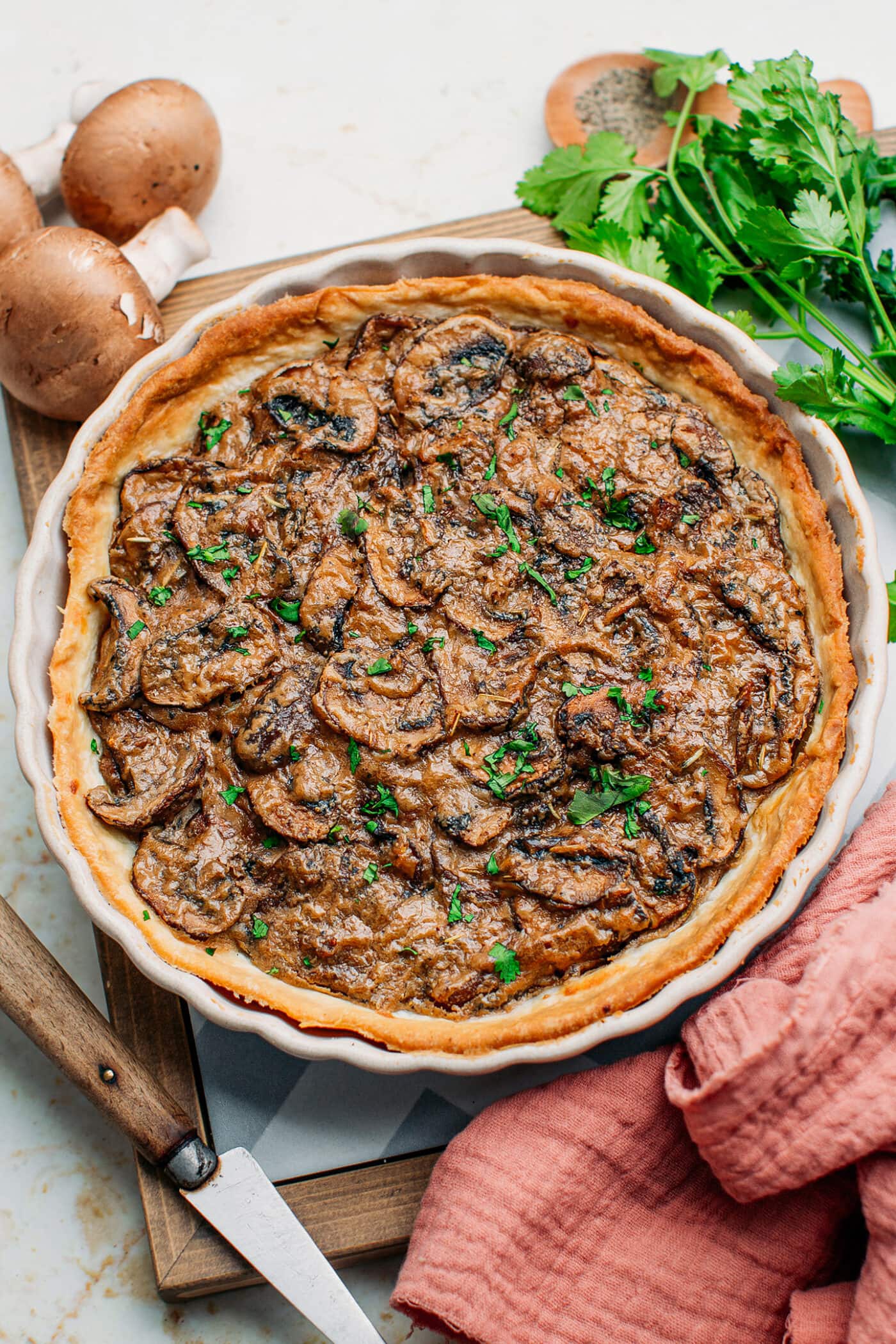Mushroom tart in a pan topped with chopped cilantro.