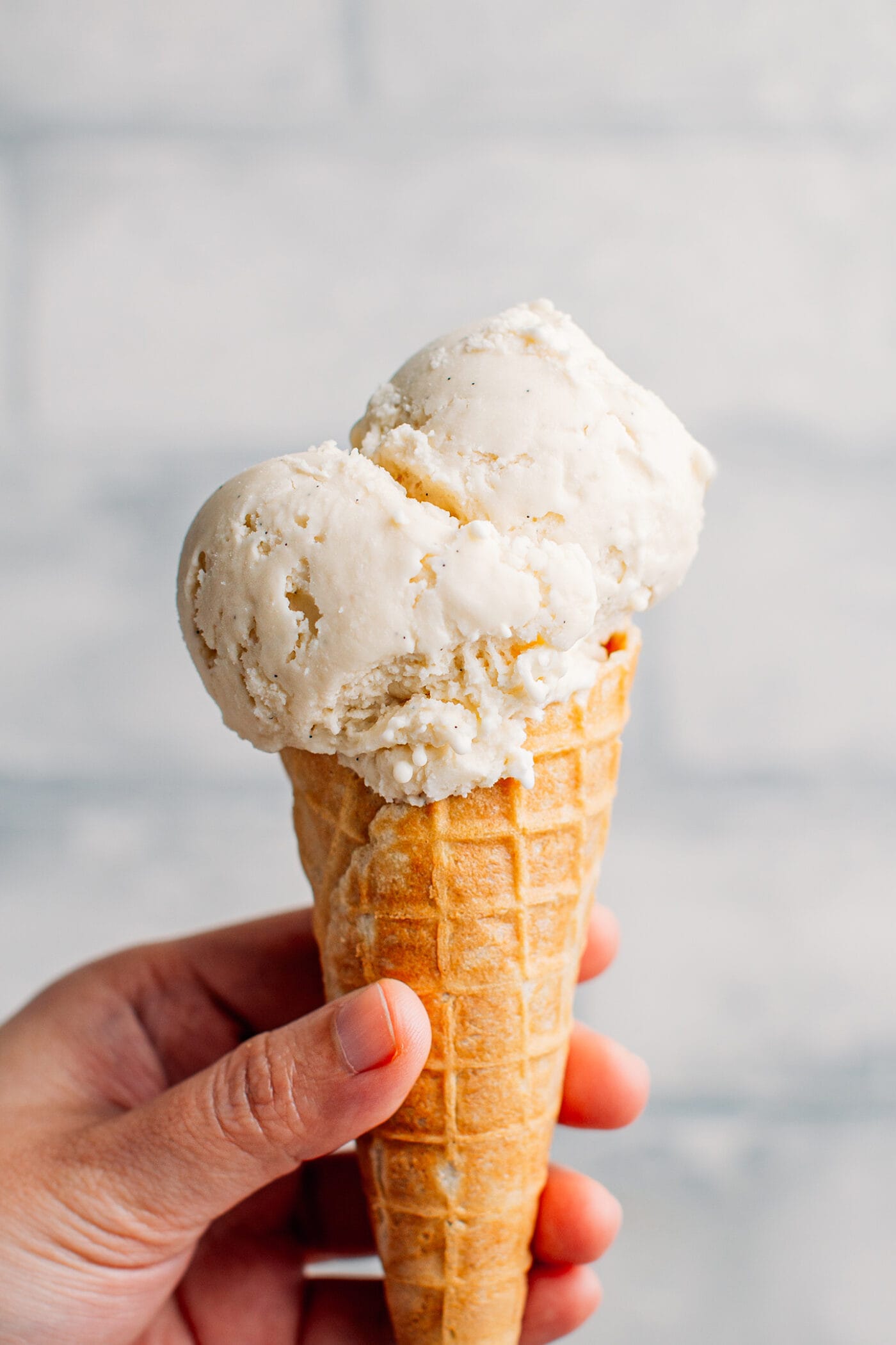 Vegan vanilla ice cream in a waffle cone.