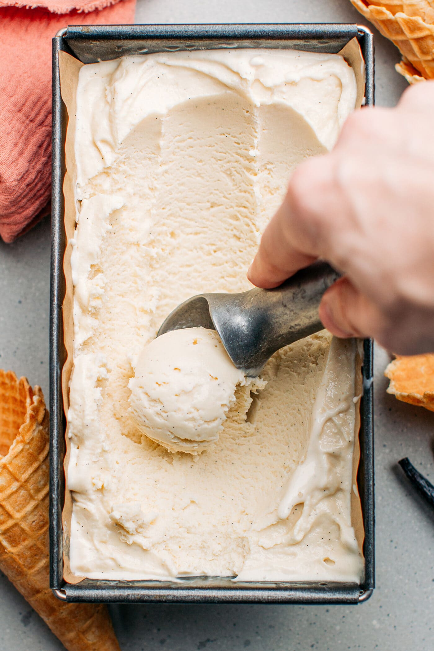 Scooping vanilla ice cream with a scoop.