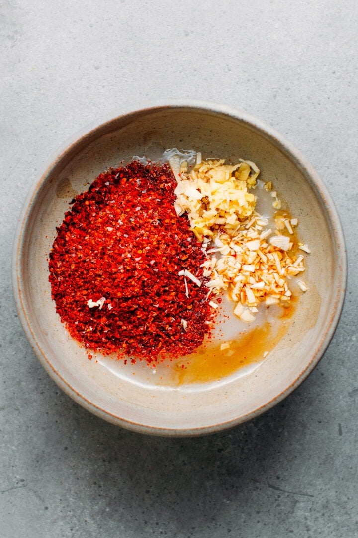 Korean chili flakes, garlic, and ginger in a bowl.
