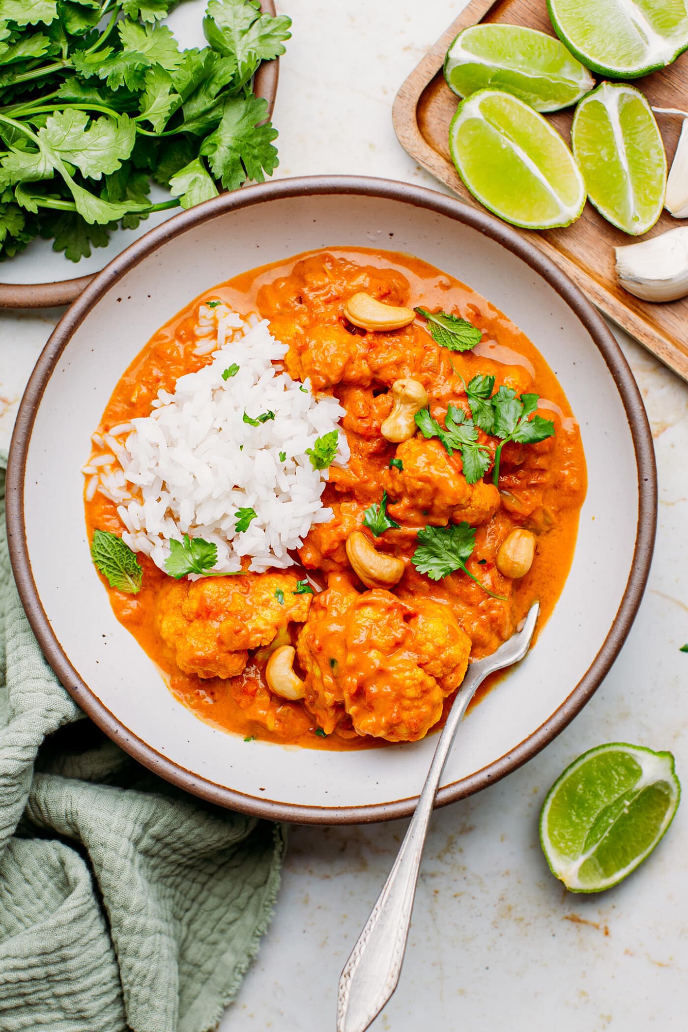 Instant Pot Cauliflower Tikka Masala in a bowl with roasted cashews, cilantro, and rice.