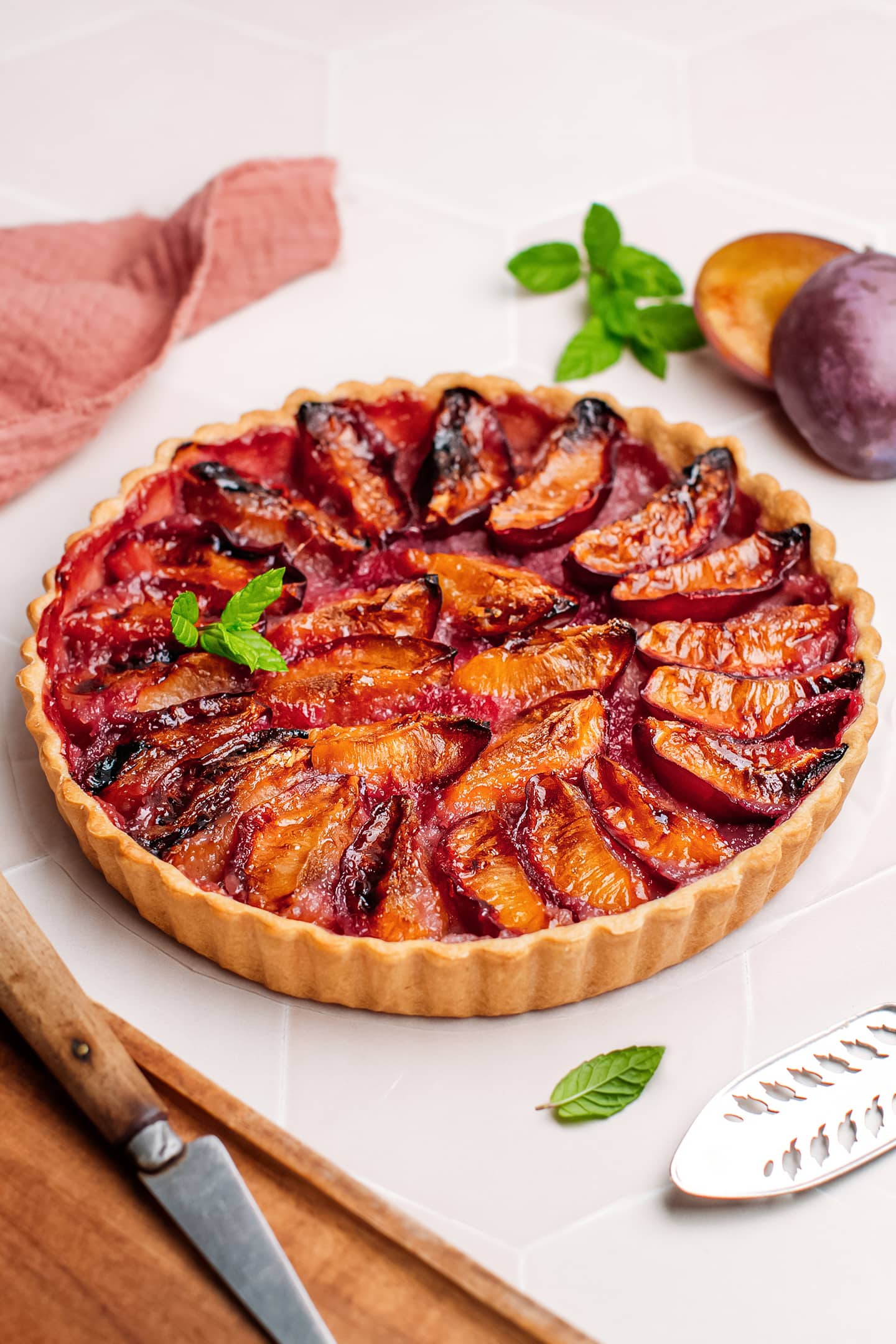 Whole plum tart topped with mint leaves.