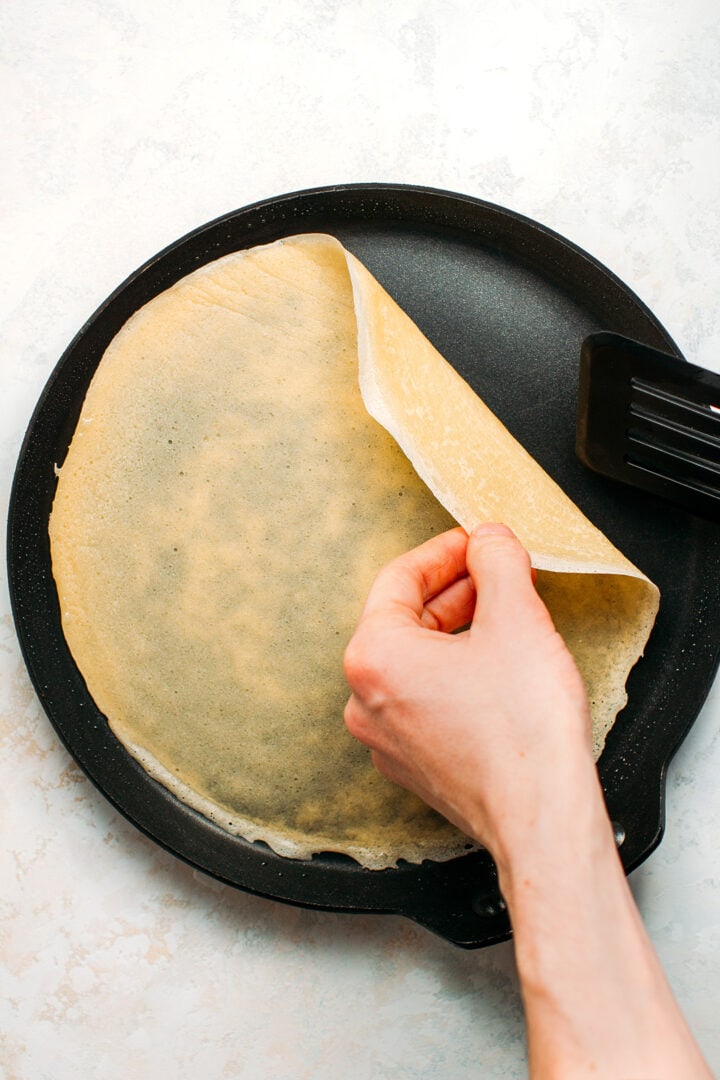 Flipping crêpe in a skillet.