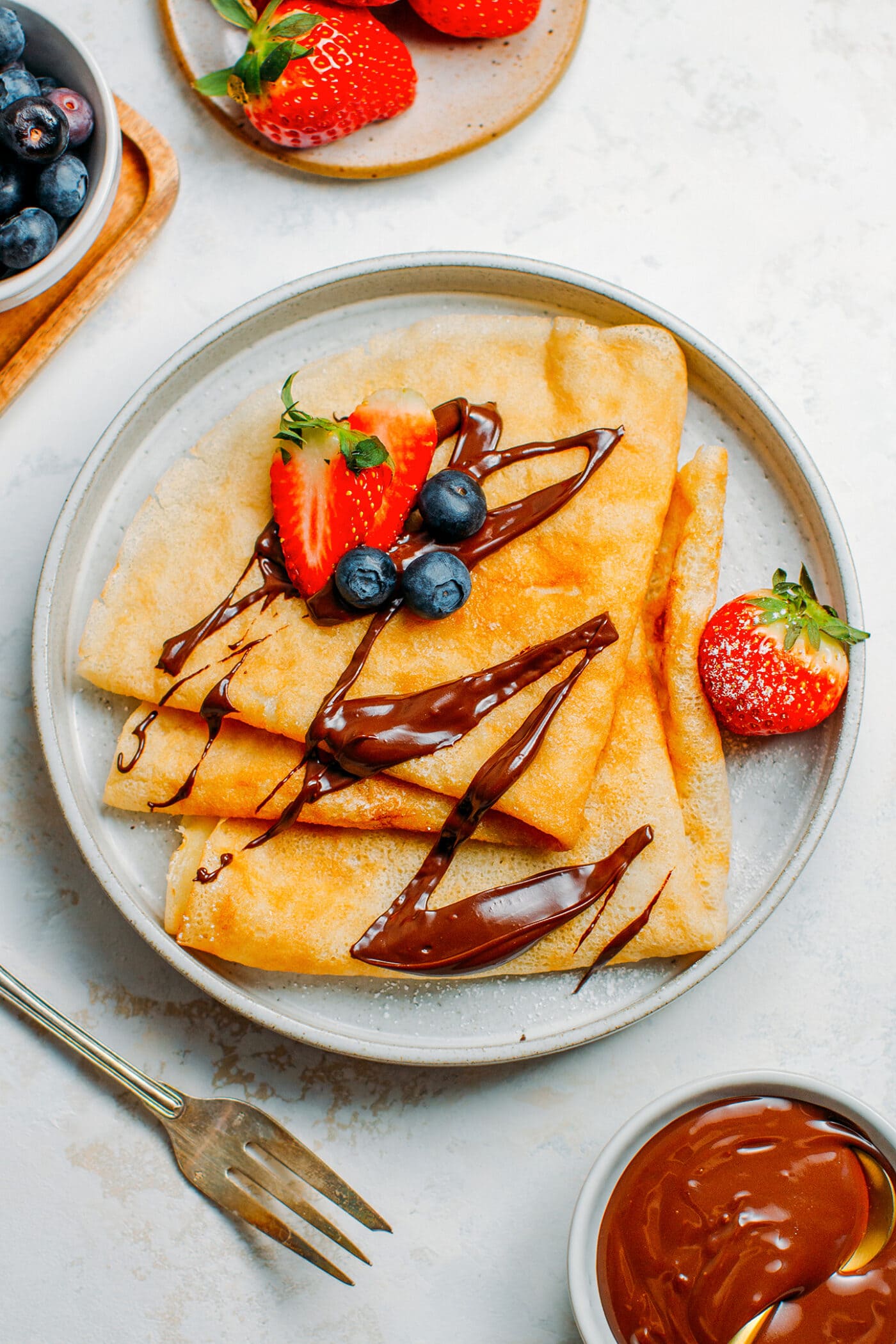 Vegan crêpes topped with chocolate spread and berries.