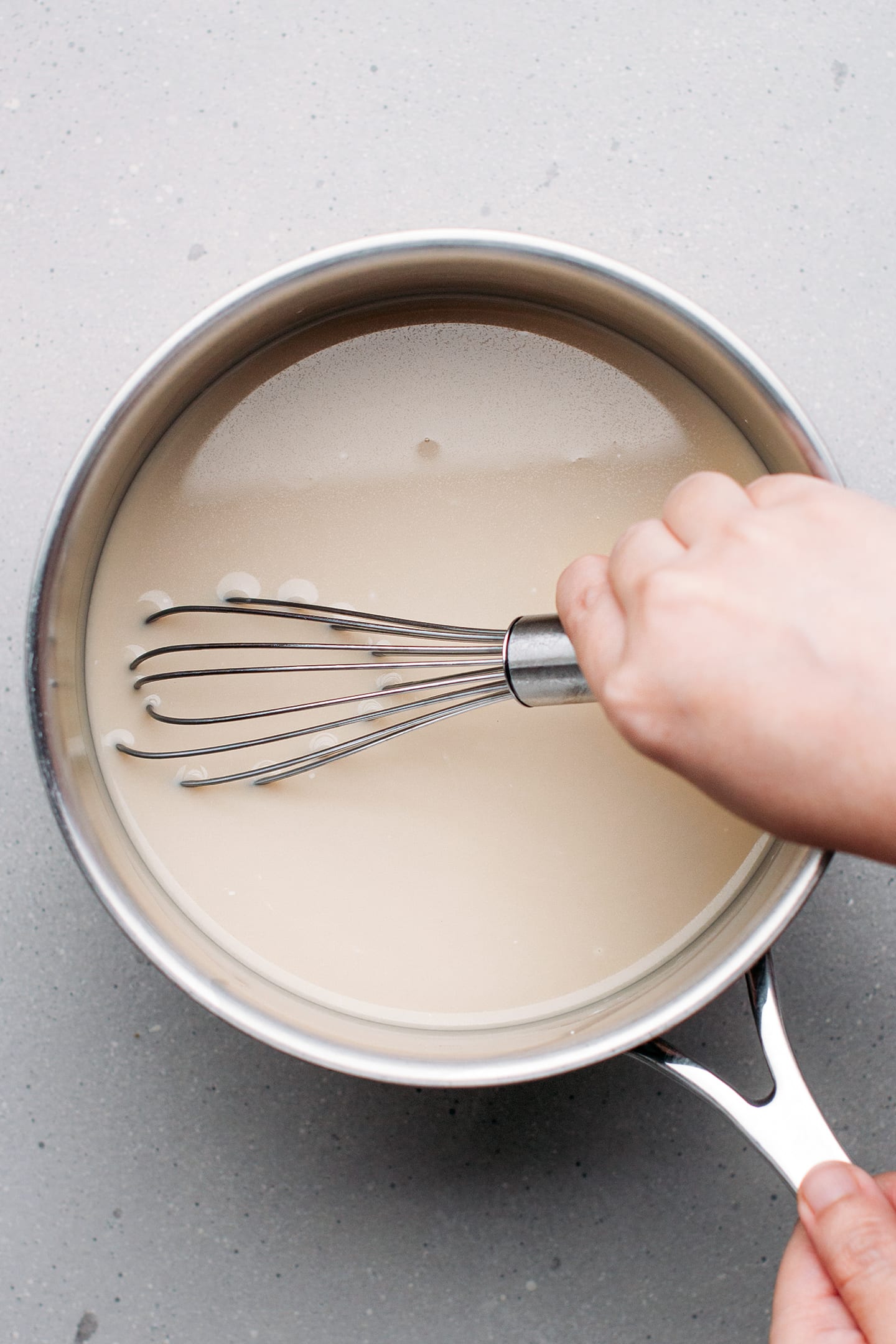 Whisking almond milk and cornstarch in a saucepan.