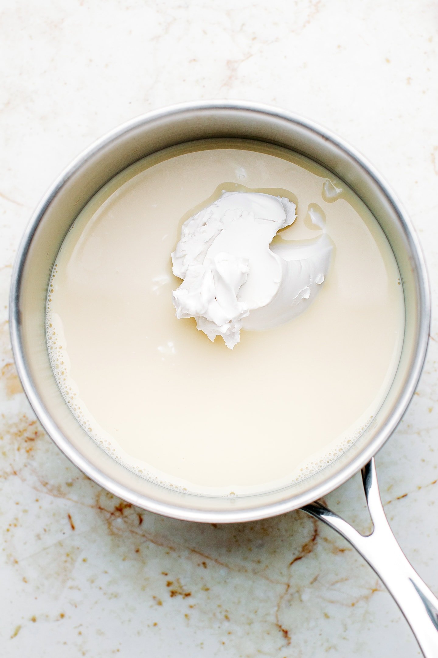 Plant-based milk and coconut cream in a saucepan.