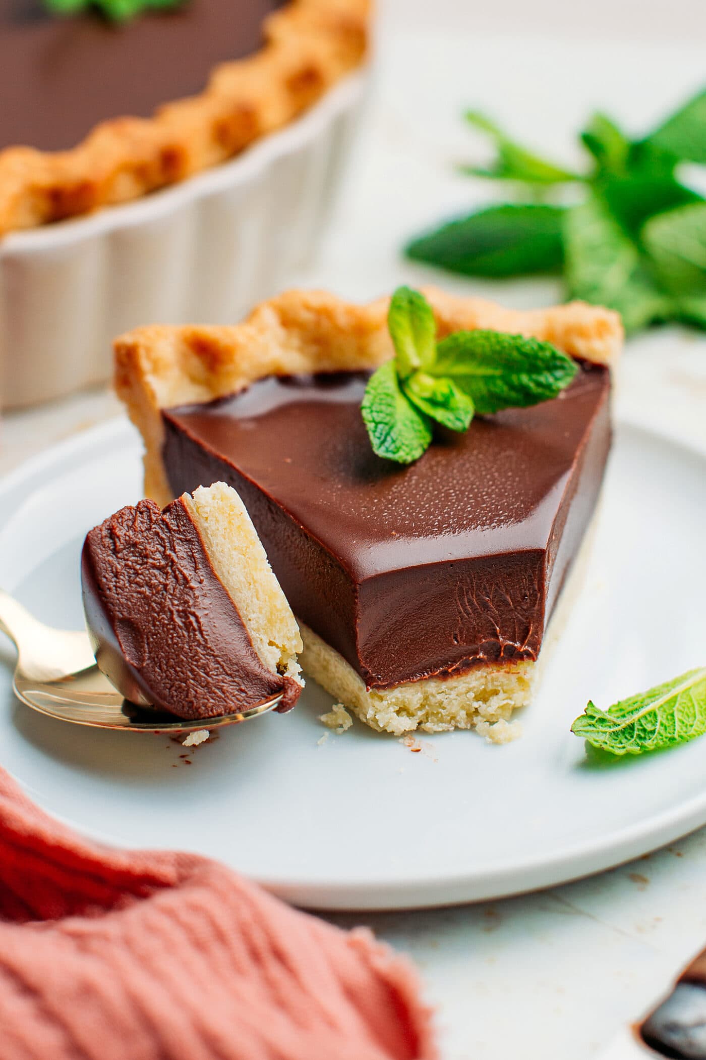 Close-up of vegan chocolate tart topped with mint.