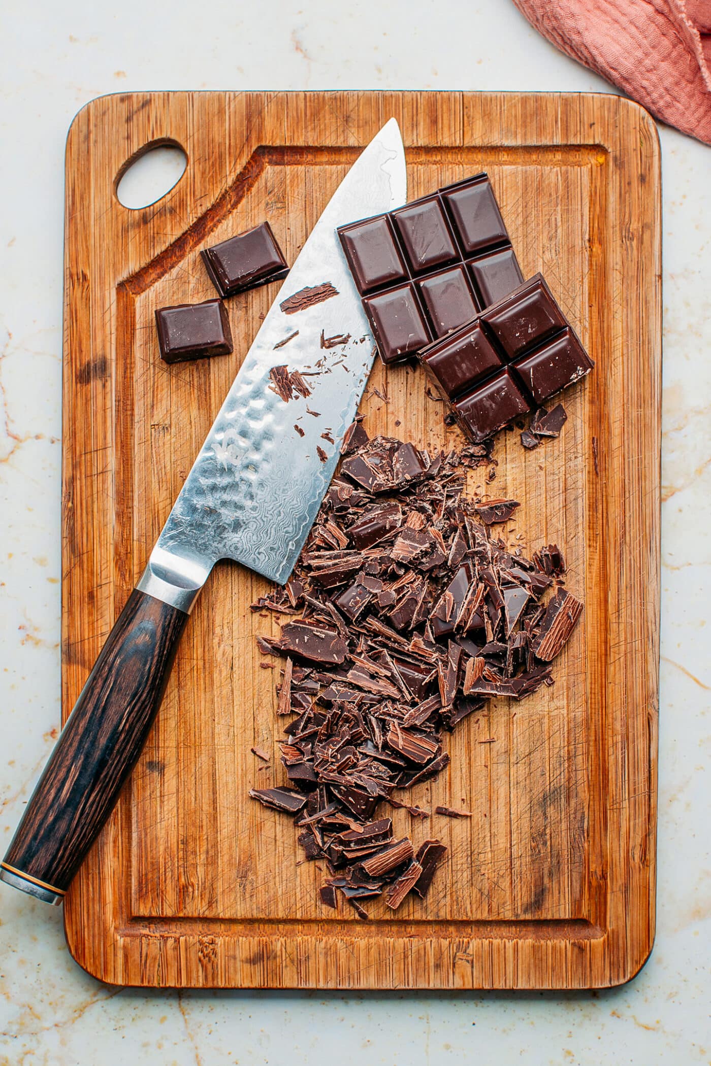 Chopped dark chocolate on a cutting board.