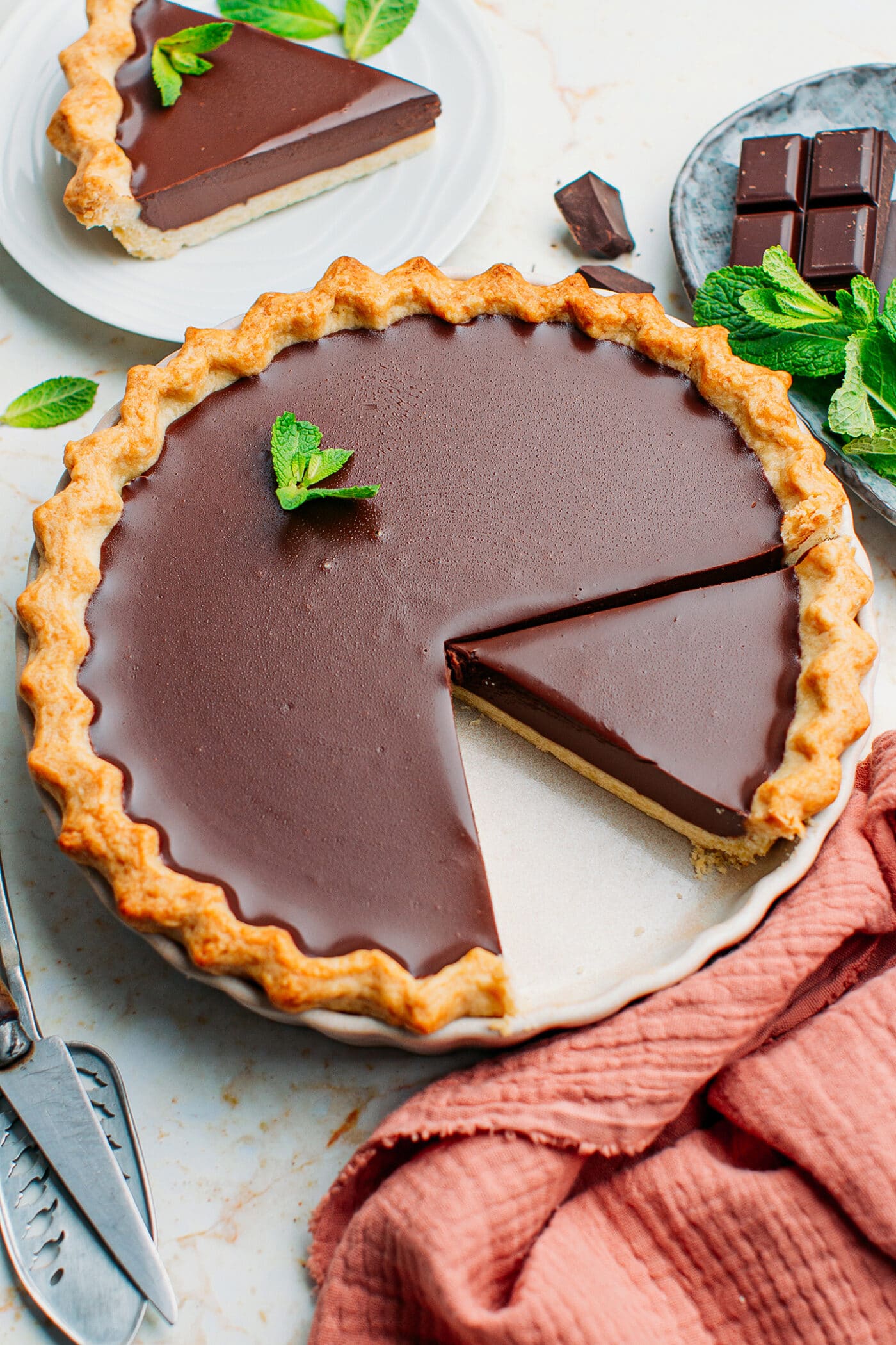 Chocolate ganache tart topped with mint leaves.