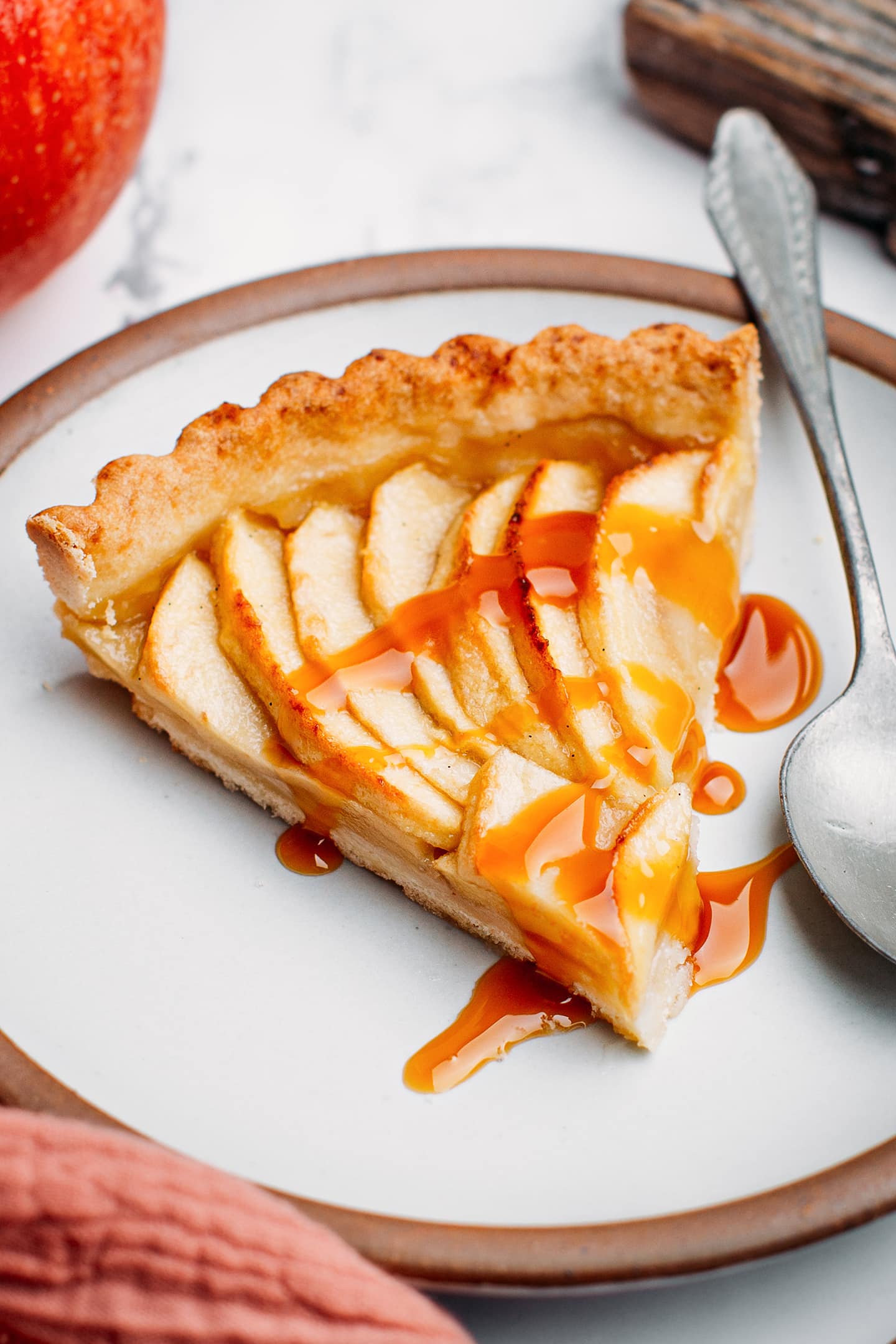 Slice of apple tart drizzled with caramel sauce.