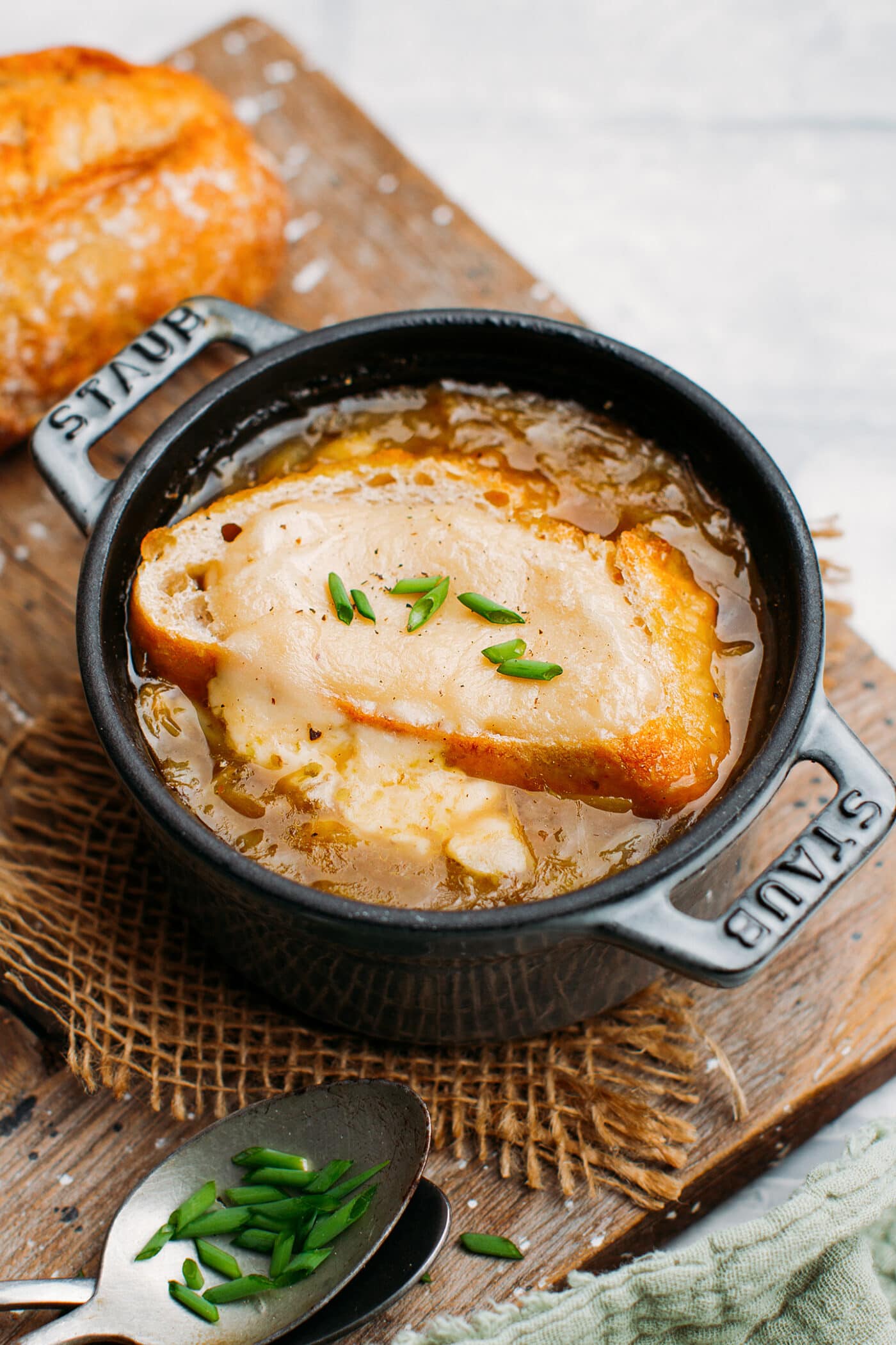 Vegan onion soup with bread and cheese sauce in a small pot.