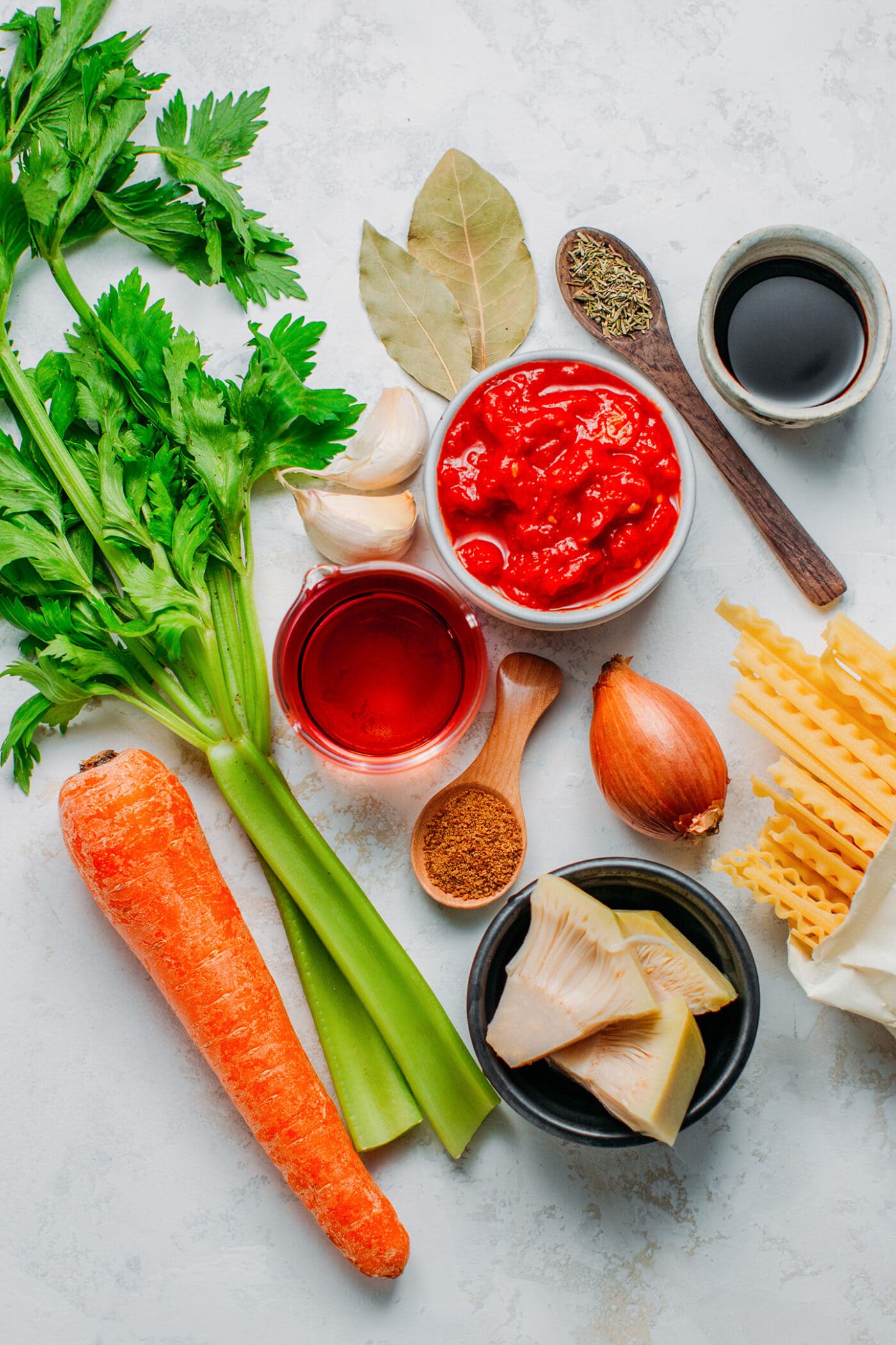 Ingredients like crushed tomatoes, shallots, red wine, jackfruit, and pasta.