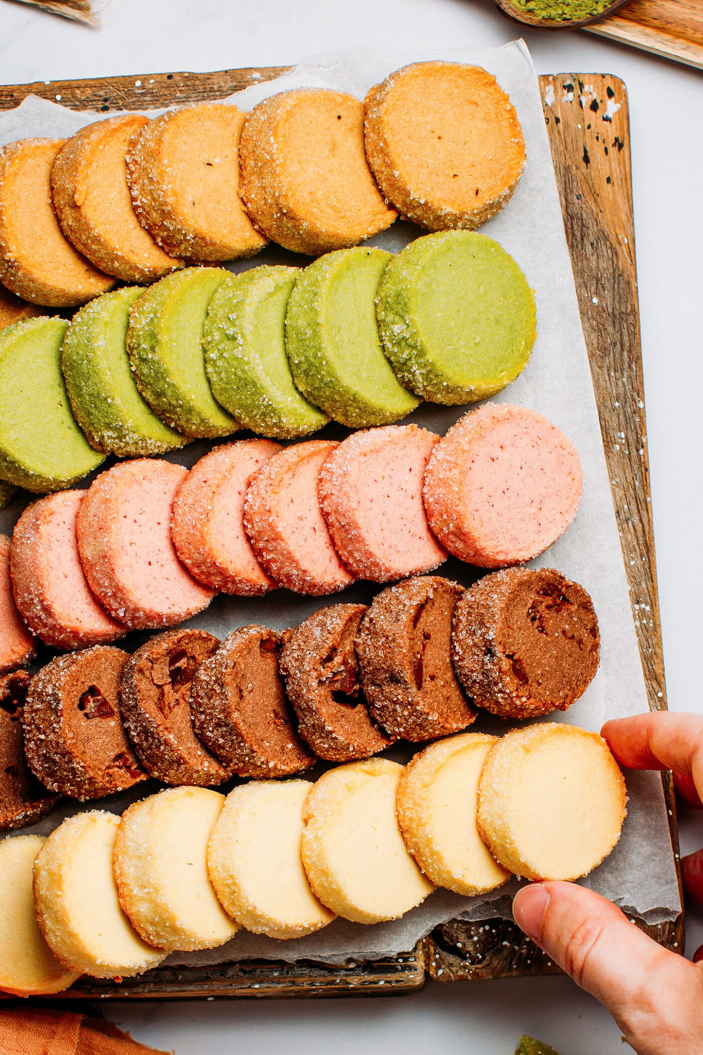 Different flavors of vegan shortbread cookies on a wooden board.