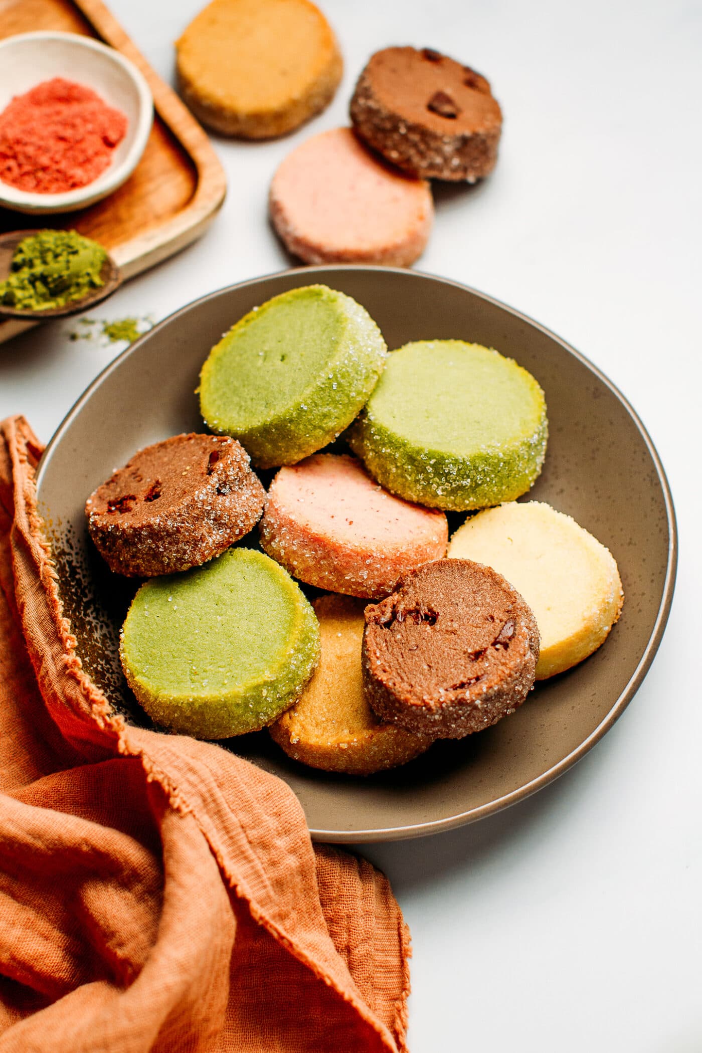 Shortbread cookies of different colors on a plate.