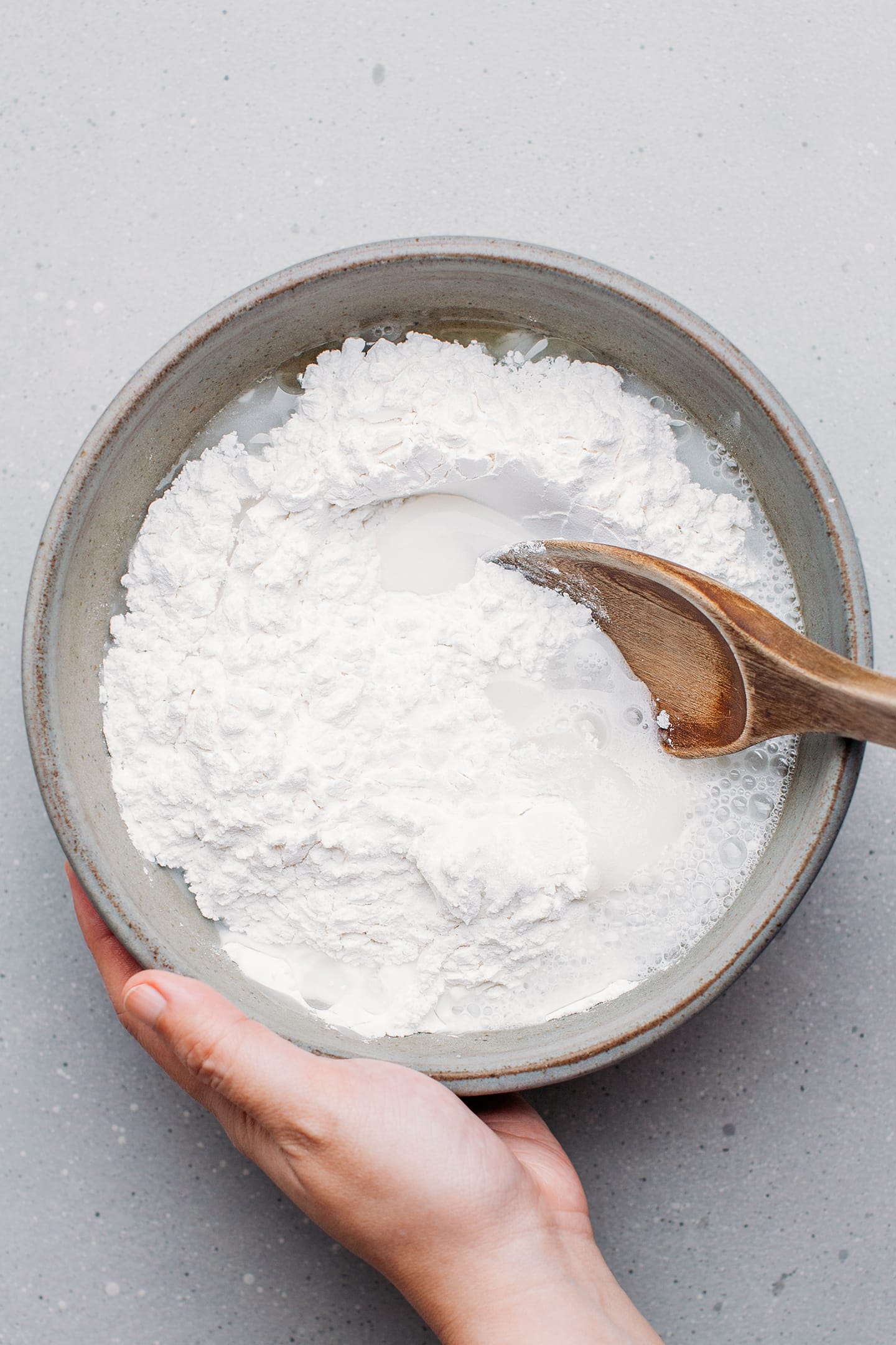 Whisking rice flour with sugar and water in a bowl.
