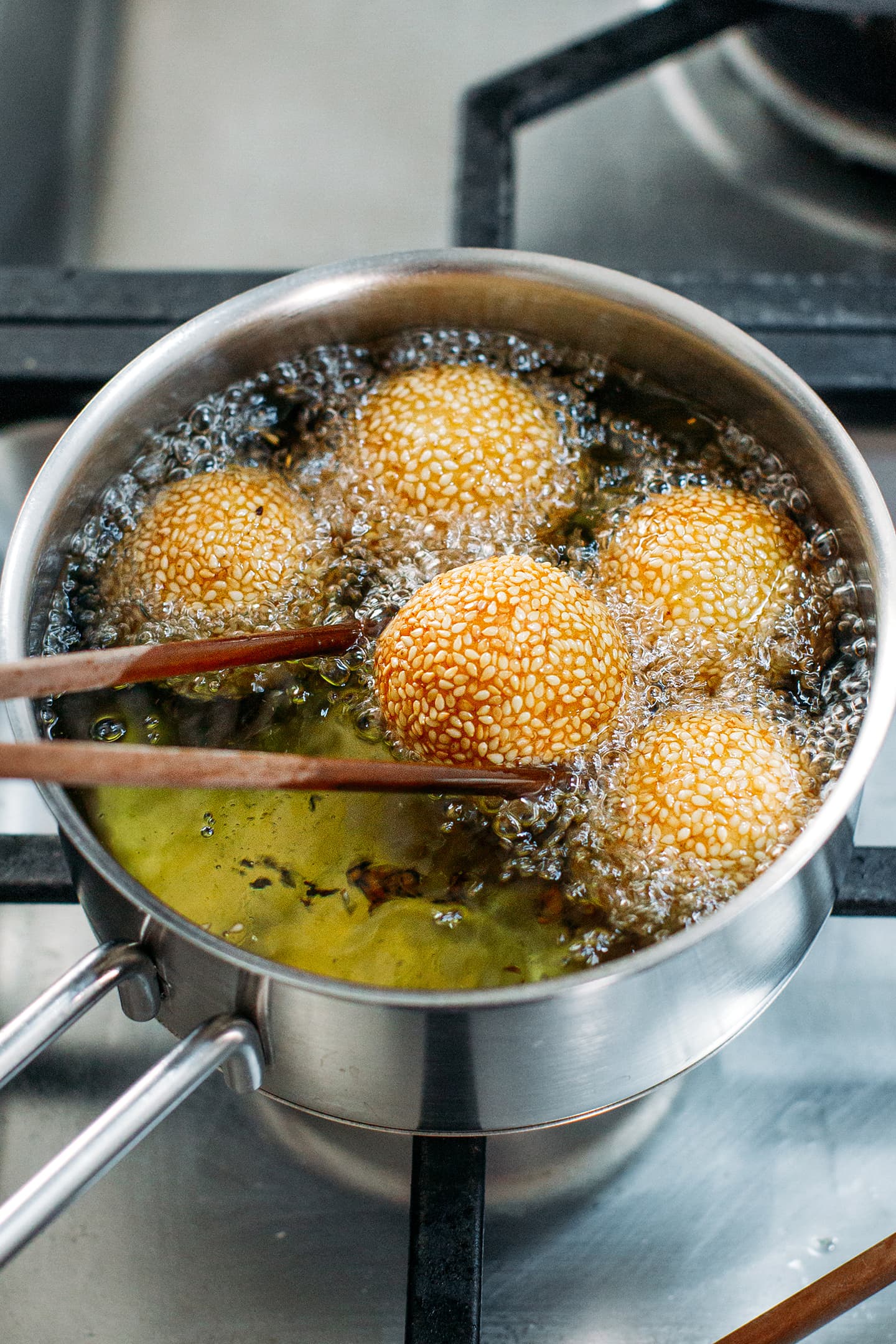 Frying sesame balls in a saucepan.